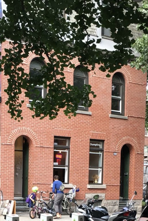 The little brick hut, Arched windows, an OPEN sign, and bikes parked out front.