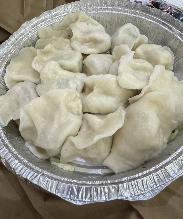 Packed to go, A tray of dumplings boxed up and ready to travel home.
